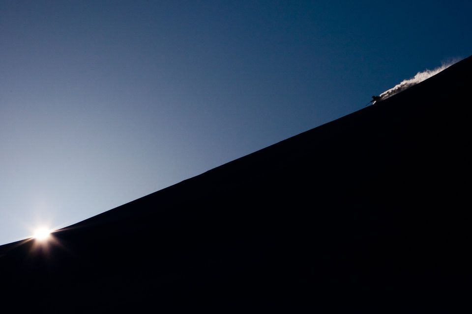 Ridge Skiing at Dawn. Christopher Cook skis a powdery ridge, snow trailing behind him like contrails. Published in Powder Magazine.